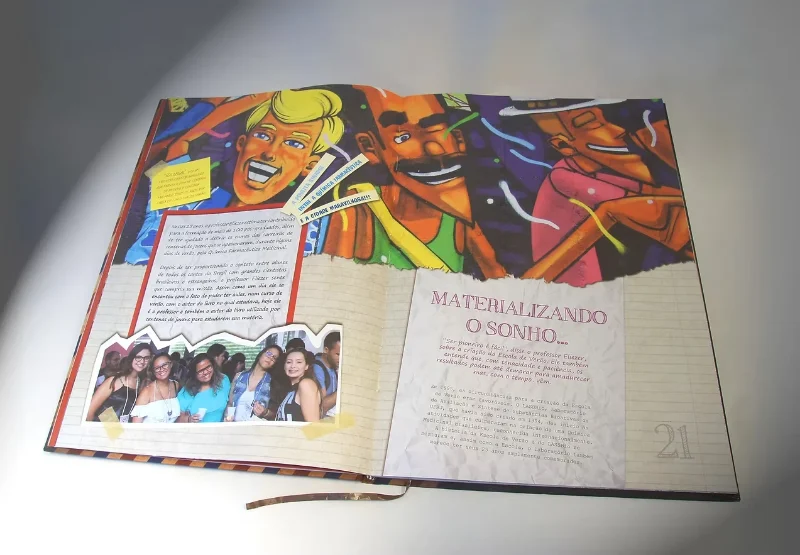 Livro comemorativo de 25 anos aberto em página dupla com grafite colorido e o título Materializando o sonho.