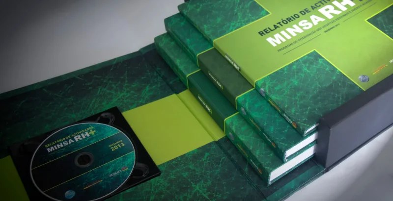 Caixa aberta do relatório de atividades MINSA RH+, com volumes em verde e o CD.
